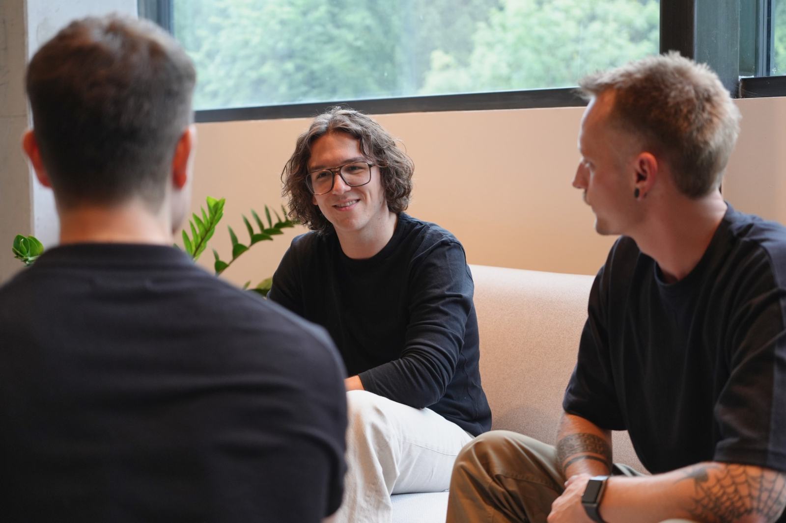 Peter und Stefan von nonoise.digital im Gespräch auf einem Sofa vor einem Fenster mit Blick ins Grüne